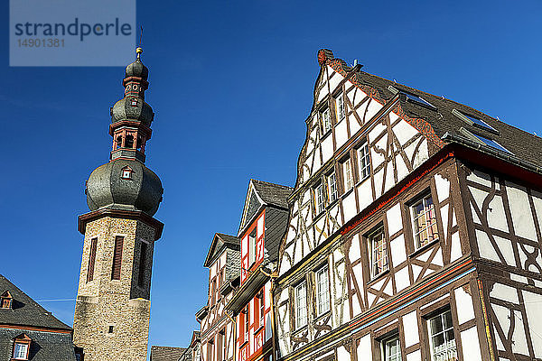 Alte mittelalterliche Gebäudefronten mit hohem Steinkirchturm und blauem Himmel; Cochem  Deutschland