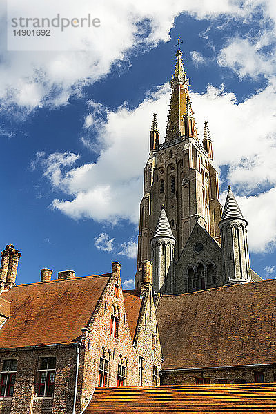 Hoher Kirchturm der Liebfrauenkirche in der mittelalterlichen Stadt Brügge mit blauem Himmel und Wolken; Brügge  Belgien