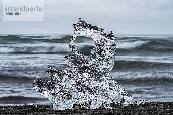 Eisbrocken am Diamond Beach in der Nähe von Jokusarlon  mit dem Meer dahinter an der Südküste Islands; Island