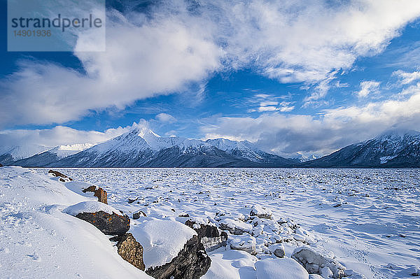 Eine Wolkenlandschaft über dem gefrorenen Cook Inlet in Süd-Zentral-Alaska mit den Chugach Mountains im Hintergrund an einem Wintertag; Alaska  Vereinigte Staaten von Amerika