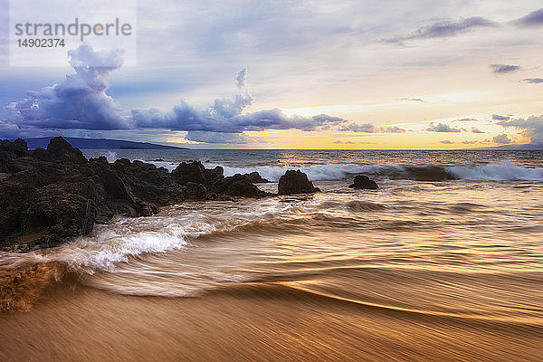 Dramatischer Sonnenuntergang am Strand mit weichem Wasser und Lavafelsen; Makena  Maui  Hawaii  Vereinigte Staaten von Amerika