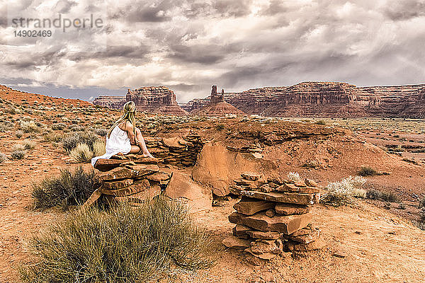 Eine Frau sitzt auf einem Felsen im Valley of the Gods; Utah  Vereinigte Staaten von Amerika