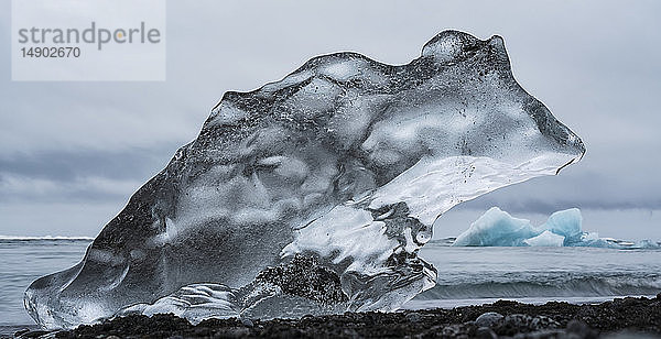 Eisbrocken am Diamantstrand in der Nähe von Jokusarlon  mit dem Meer dahinter an der Südküste Islands; Island