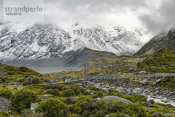 Schneebedeckte Berge und Hängebrücke entlang des Hooker Valley Track  Mount Cook National Park; Südinsel  Neuseeland