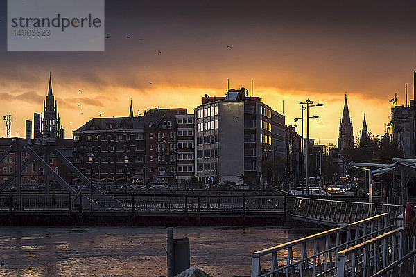 Dramatischer goldener Himmel über einem städtischen Stadtbild bei Sonnenuntergang; Irland