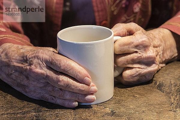 Ältere Frau hält eine Kaffeetasse in den Händen; Olympia  Washington  Vereinigte Staaten von Amerika