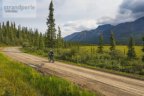 Ein Mann auf der Nabesna Road im Wrangell-St. Elias National Park and Preserve an einem bewölkten Sommertag in Süd-Zentral-Alaska; Alaska  Vereinigte Staaten von Amerika