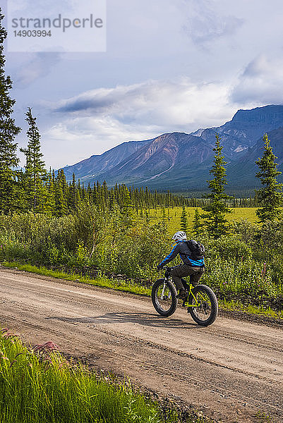 Ein Mann auf der Nabesna Road im Wrangell-St. Elias National Park and Preserve an einem bewölkten Sommertag in Süd-Zentral-Alaska; Alaska  Vereinigte Staaten von Amerika