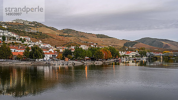 Douro-Fluss mit Häusern am Ufer und bunten Hängen  Douro-Tal; Pinhao  Bezirk Viseu  Portugal