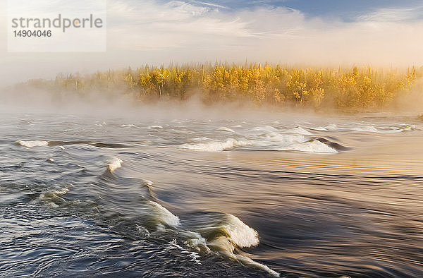 Nebel hängt über den Sturgeon Falls mit goldenem Laub an den Bäumen im Herbst  Whiteshell Provincial Park; Manitoba  Kanada