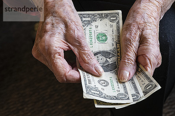 Die Hände einer älteren Frau zählen ein paar Dollar; Olympia  Washington  Vereinigte Staaten von Amerika