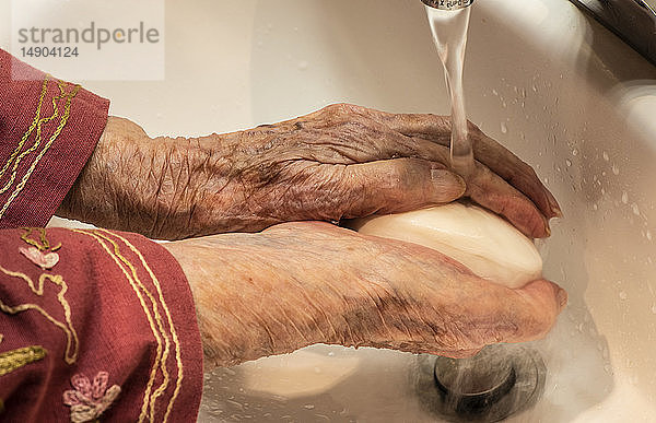 Ältere Frau wäscht sich die Hände; Olympia  Washington  Vereinigte Staaten von Amerika