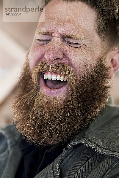 Bildnis eines lachenden  bärtigen Mannes mit hellbraunem Haar.