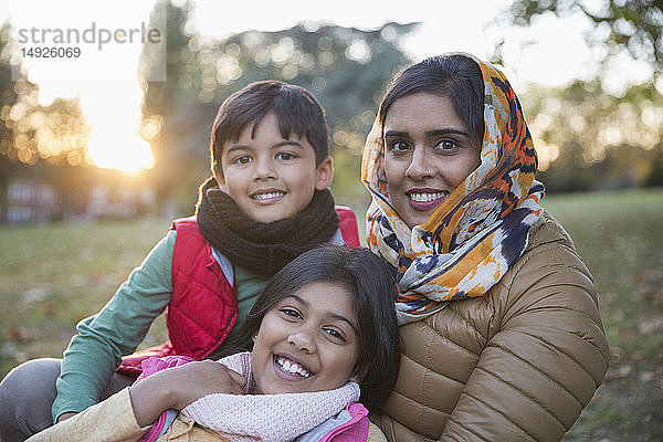 Porträt glückliche muslimische Mutter im Hidschab mit Kindern im Herbstpark