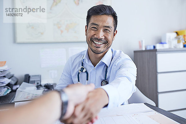 Ansicht eines glücklichen Arztes  der dem Patienten die Hand schüttelt