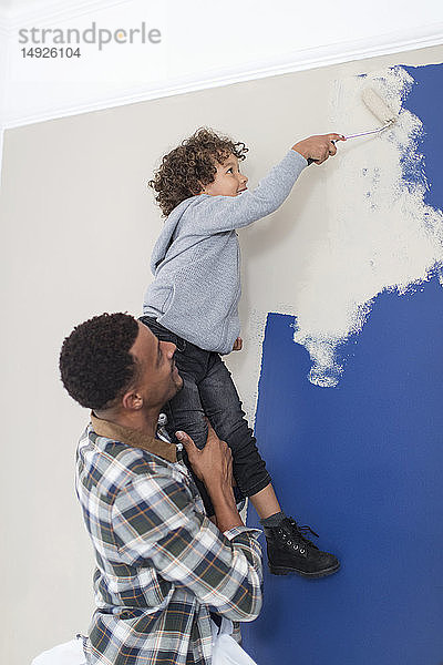 Vater und Sohn malen die Wand