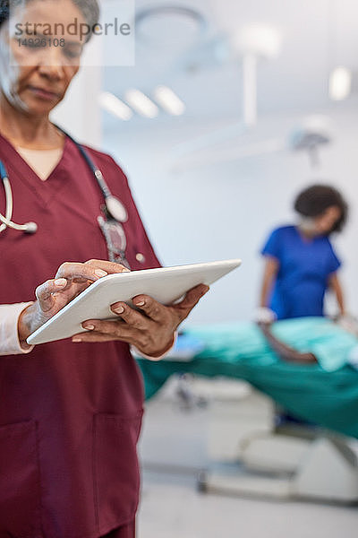 Ärztin mit digitalem Tablet in der Klinik