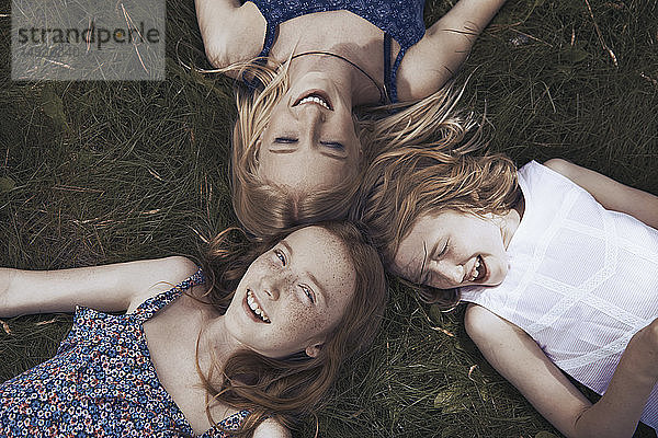 Porträt glückliche Schwestern im Gras liegend