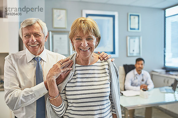 Porträt eines glücklichen älteren Paares beim Verlassen einer Arztpraxis