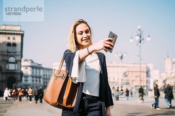 Junge Touristin beim Smartphone-Selfie auf dem Stadtplatz  Mailand  Italien