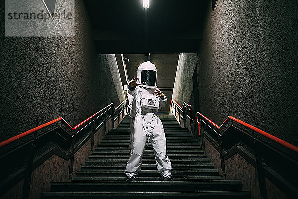 Astronaut gestikuliert auf der Treppe