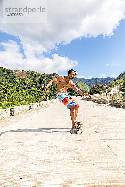 Mann fährt Skateboard auf der Strasse  Pagudpud  Ilocos Norte  Philippinen