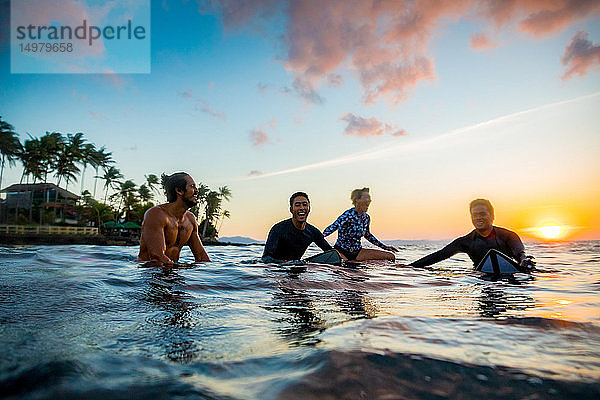 Surfer  die bei Sonnenuntergang im Meer gleiten  Pagudpud  Ilocos Norte  Philippinen