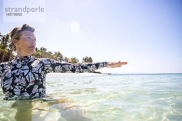 Frau streckt ihre Hand im Meer aus  Pagudpud  Ilocos Norte  Philippinen