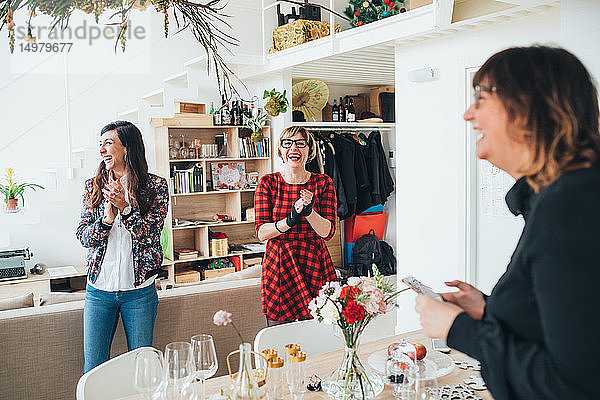 Freunde klatschen bei Feier im Loft-Büro in die Hände