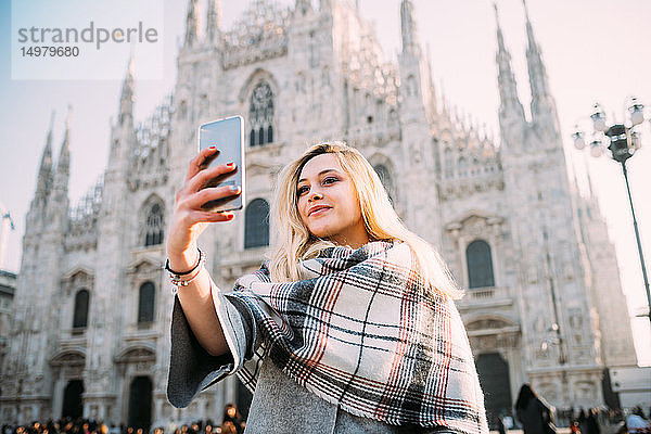 Junge Touristin beim Smartphone-Selfie vor dem Mailänder Dom  Mailand  Italien