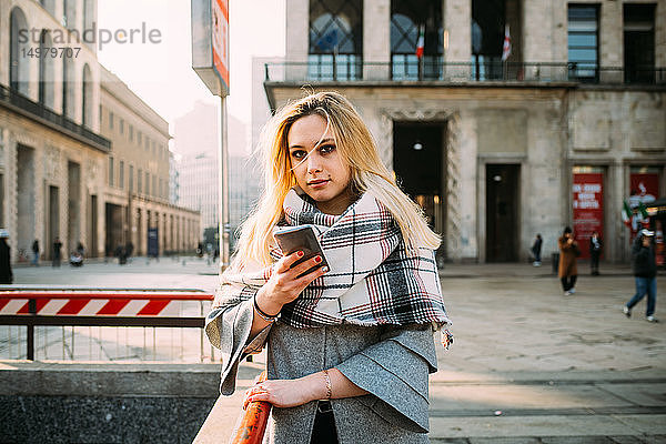 Junge Frau mit Smartphone bei der U-Bahn-Station  Portrait  Mailand  Italien
