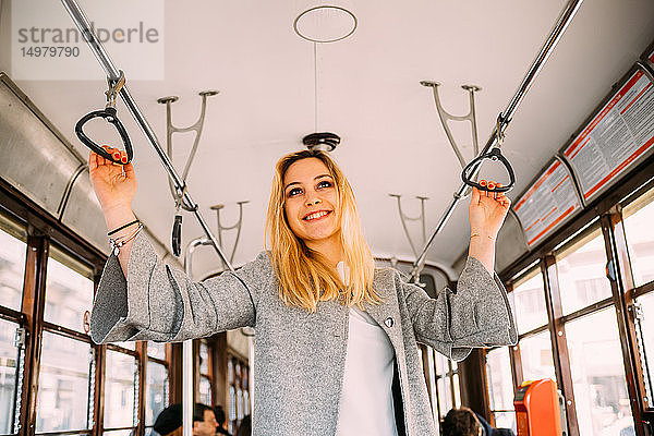 Junge Frau mit langen blonden Haaren in der Stadtbahn