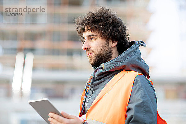 Mann benutzt digitales Tablett auf der Straße