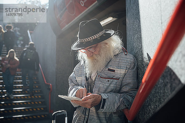 Älterer Mann benutzt digitales Tablett am Eingang zur U-Bahn  Mailand  Lombardei  Italien