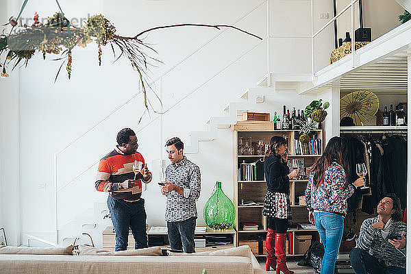 Freunde unterhalten sich auf einer Party im Loft-Büro