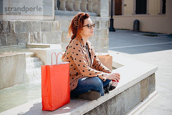 Shopperin macht Pause vor dem Springbrunnen  Arezzo  Toskana  Italien