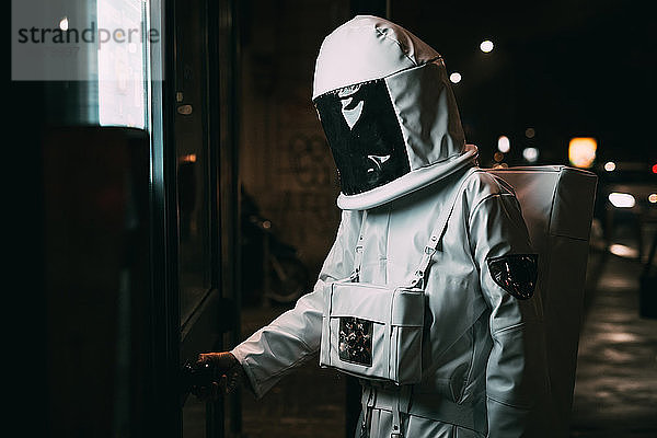 Astronaut öffnet nachts die Tür zum Einkaufen