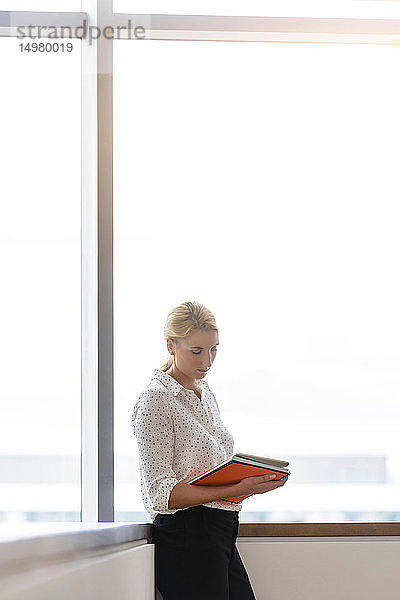Geschäftsfrau benutzt digitales Tablett im Korridor