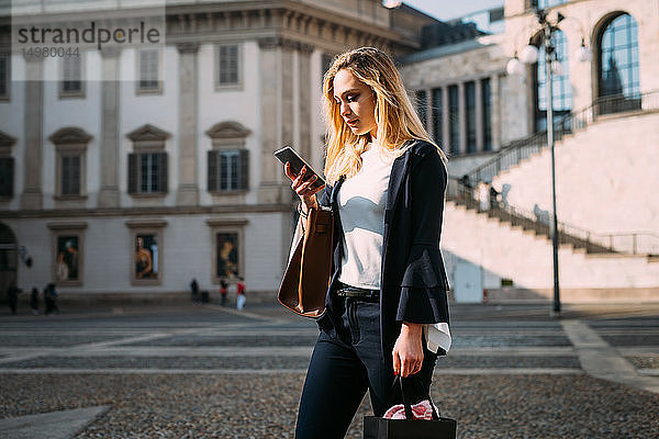 Junge Touristin mit Smartphone auf dem Stadtplatz  Mailand  Italien