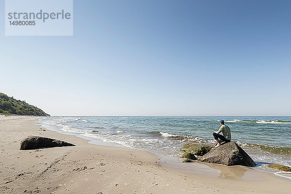 Mann auf Strandfelsen sitzend  Putgarten  Rugen  Mecklenburg-Vorpommern  Deutschland