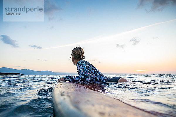 Surfer  der bei Sonnenuntergang im Meer gleitet  Pagudpud  Ilocos Norte  Philippinen