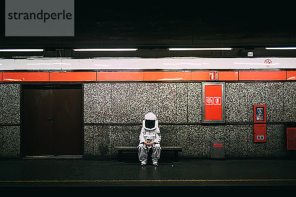 Astronaut wartet auf dem Bahnsteig