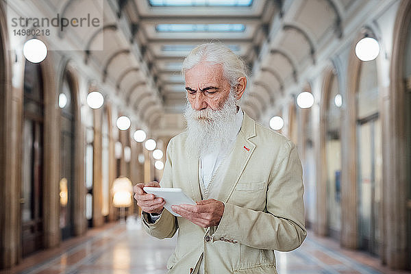 Leitender Geschäftsmann benutzt digitales Tablet im Bürogebäude  Mailand  Lombardei  Italien