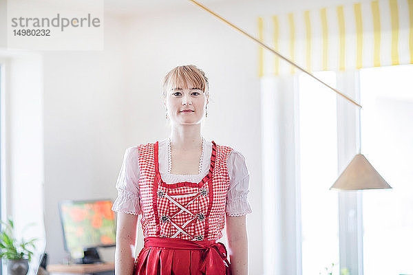 Frau trägt Dirndl im Home-Office