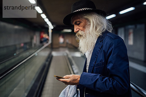 Leitender Geschäftsmann benutzt Smartphone im Terminal