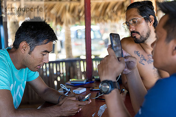 Freunde benutzen Smartphone in Strandhütte  Pagudpud  Ilocos Norte  Philippinen