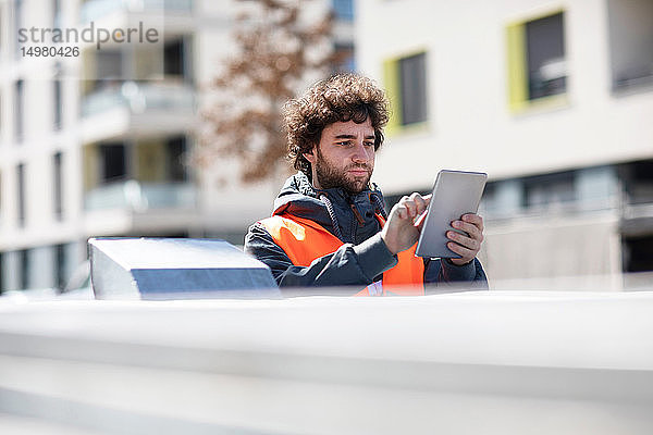 Mann benutzt digitales Tablett auf der Straße