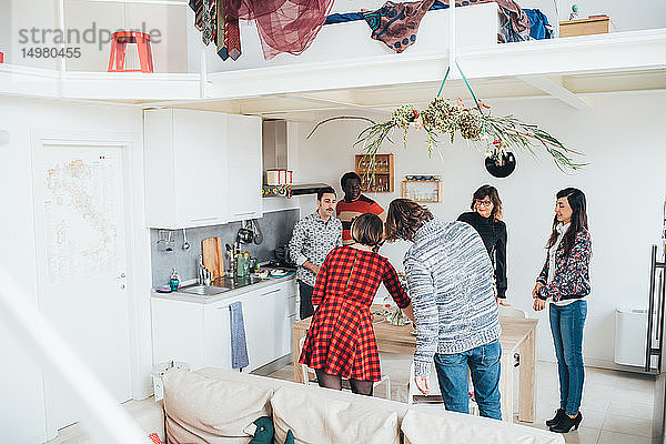 Freunde unterhalten sich auf einer Party im Loft-Büro