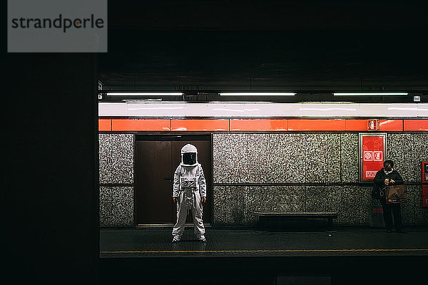 Astronaut wartet auf dem Bahnsteig