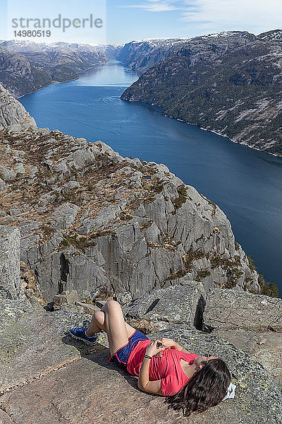 Wanderer  der sich auf dem Gipfel einer Klippe ausruht  Preikestolen (Kanzelfelsen)  Lysefjord  Norwegen  Stavanger